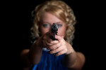 portrait of the blonde with gun isolated on black background