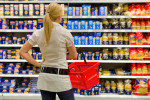 Eine Frau ist mit der großen Auswahl in einem Supermarkt beim Einkauf überfordert.
